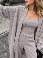 Women's three-piece ribbed knit sweater outfit with long open-front cardigan, strapless tube top and matching wide-leg pants.