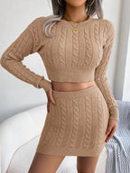 Women's cable-knit two-piece sweater set with cropped long-sleeve round neck top and matching high-waisted mini skirt.