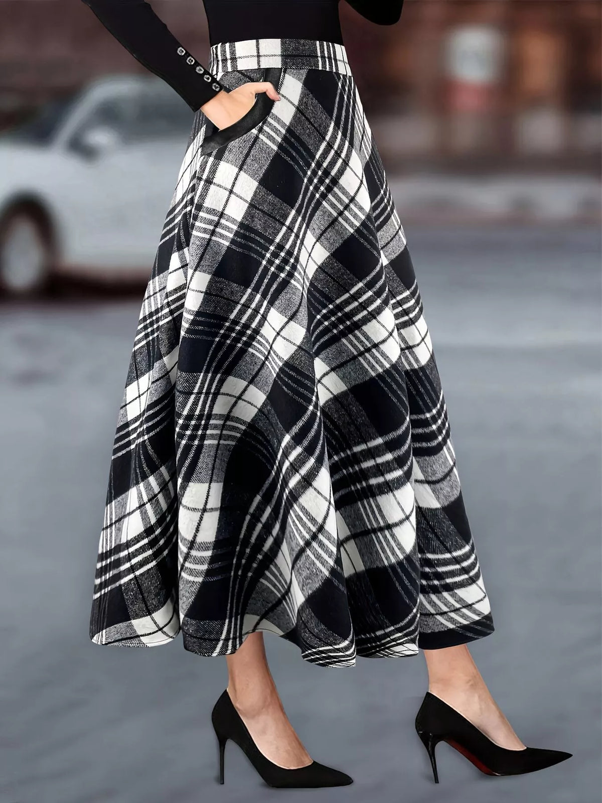 Women's black and white plaid high-waisted A-line midi skirt with flowing silhouette and functional side pockets.