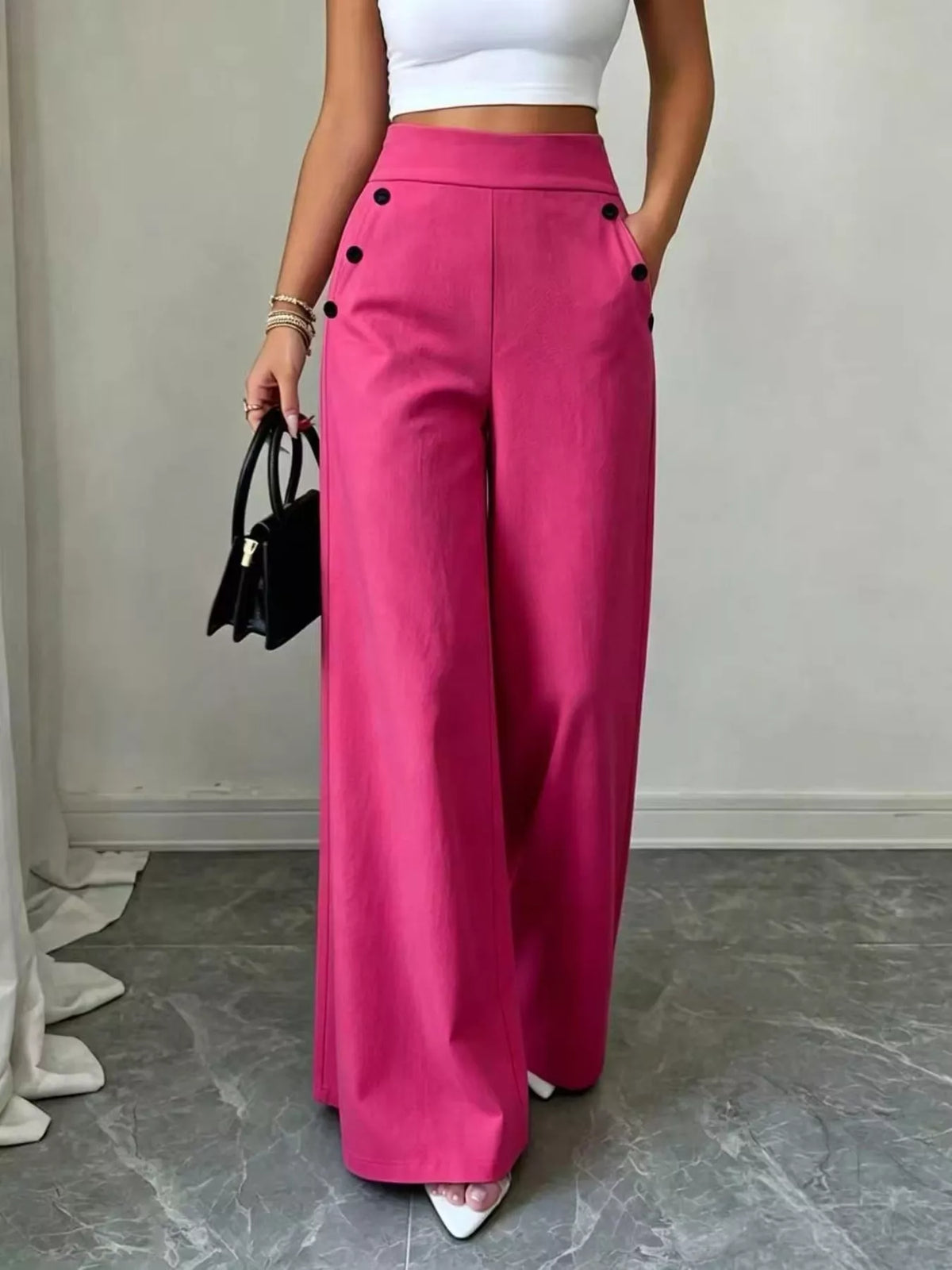 Women's high-waisted wide-leg dress pants with decorative button accents, side pockets and flowing silhouette.