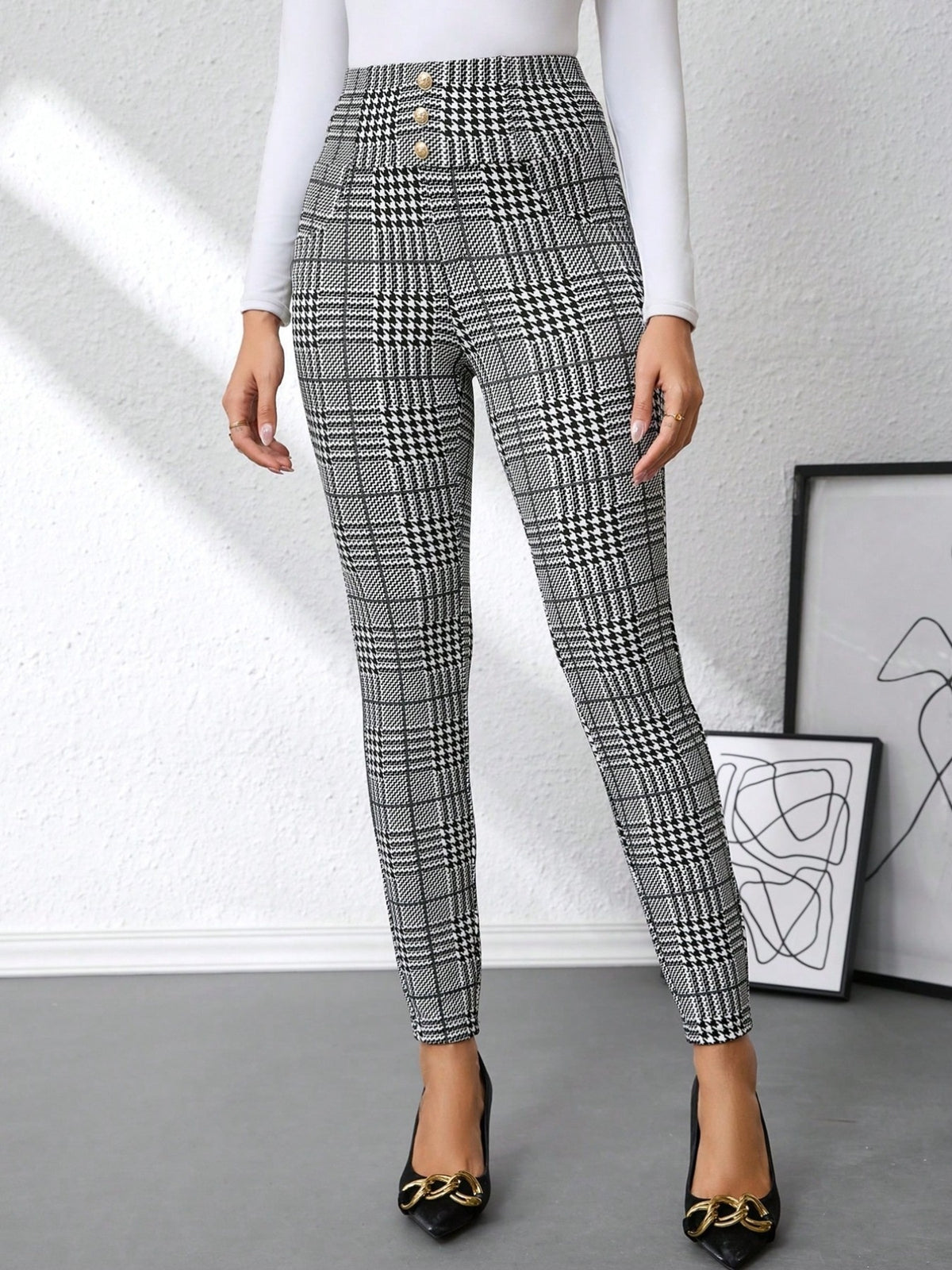 Women's black and gray plaid high-waisted slim-fit pants with decorative button accents and tailored silhouette.