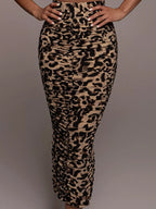 Women's leopard print high-waisted ruched maxi skirt with fitted bodycon silhouette and side slit.