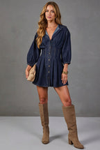 Women's dark blue button-down denim mini dress with three-quarter puff sleeves, fitted waist, seam details and flared hem.