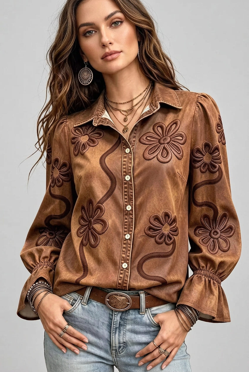 Women's floral embroidered button-down shirt with decorative swirl pattern and ruffled cuffs, available in Caramel, Dusty Blue, and Moss, sizes S–5XL.
