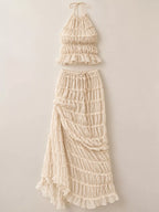 Women's boho two-piece outfit with ruffled halter crop top, open-back tie details and flowing tiered maxi skirt.