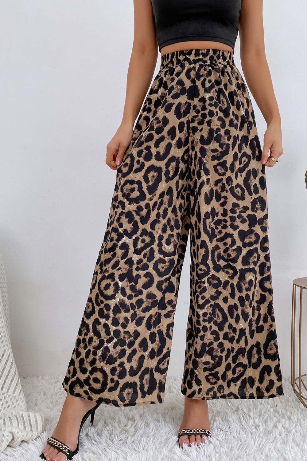 Women's leopard print high-waisted wide-leg pants with flowing legs and relaxed silhouette.
