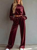 Women's velvet-look two-piece lounge set with long-sleeve cropped sweatshirt and matching drawstring wide-leg pants with pockets.